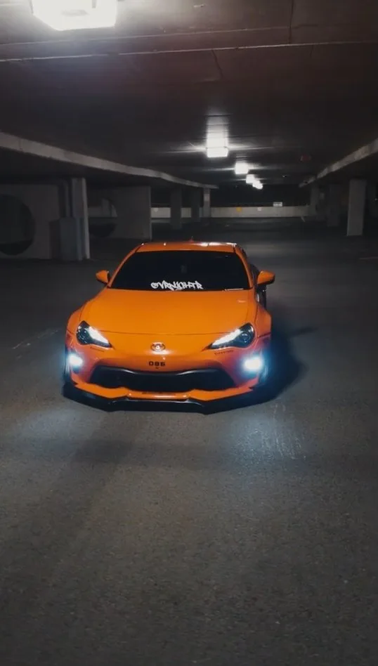 Source clip: an orange car in a parking garage